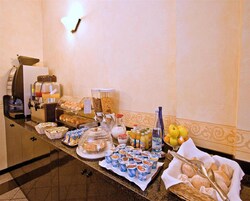 Een buffet met diverse gerechten, waaronder gebak, fruit en drankjes.