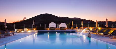 Una piscina cubierta, una piscina al aire libre, tumbonas