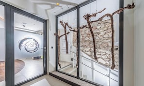 Un interior moderno con el logotipo de un spa, una pared de piedra y una escalera.