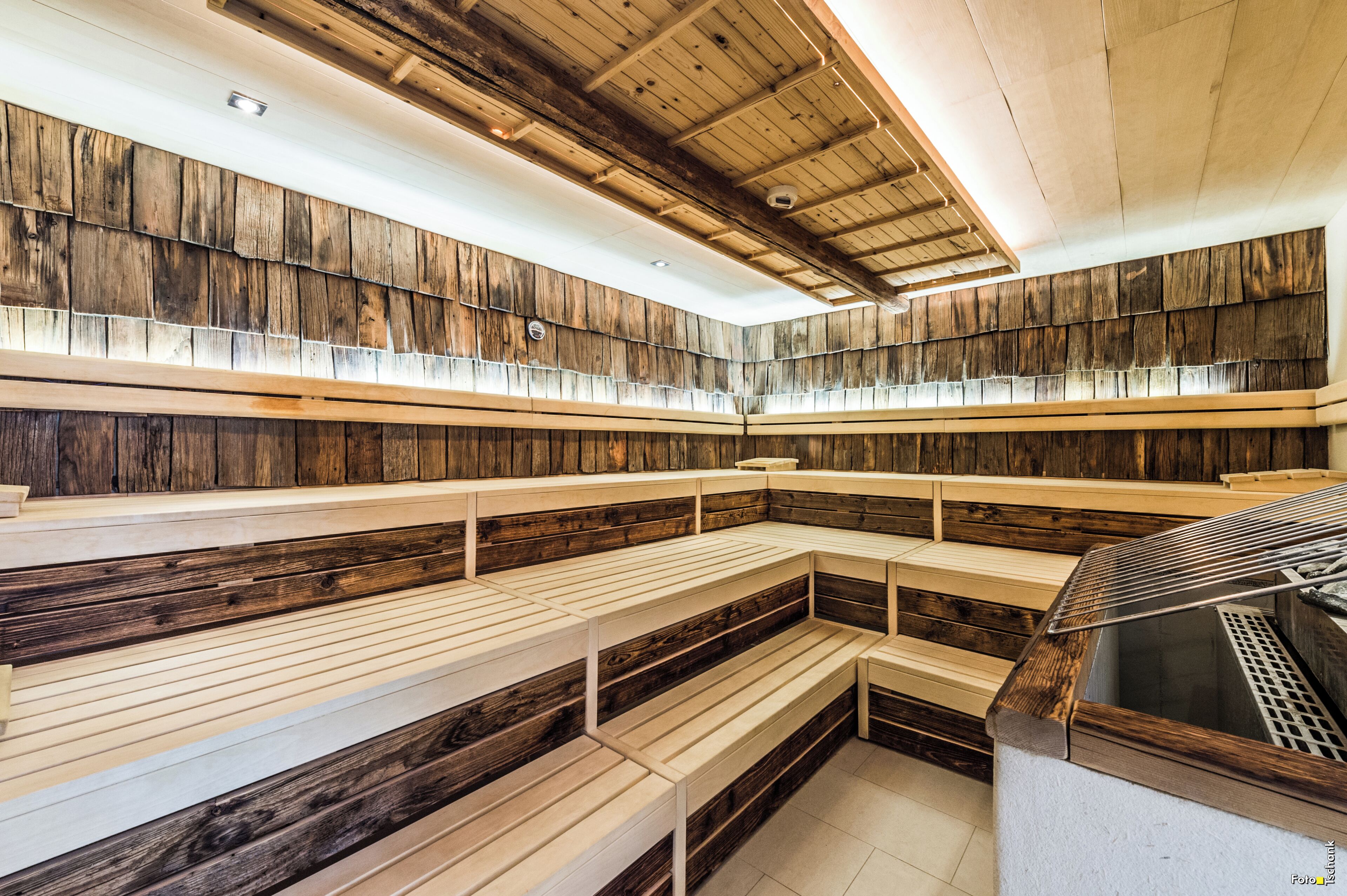 A sauna with wooden benches and a sloped ceiling.