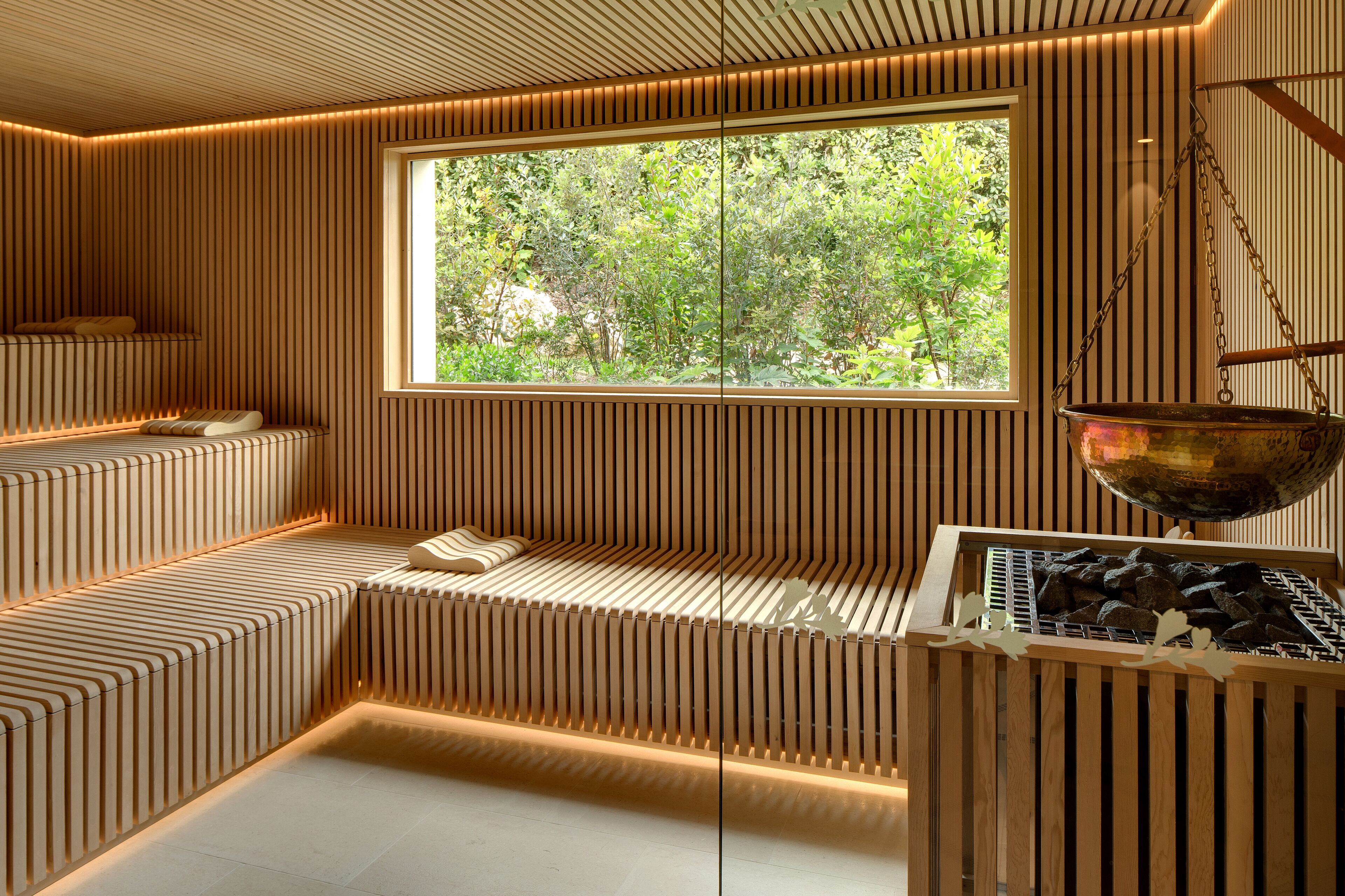 Un intérieur moderne avec une grande fenêtre, des sièges en bois à lattes et un bol en métal.