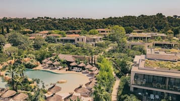 Un resort con piscina, sillones de descanso y sombrillas.
