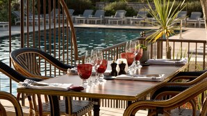 A dining table with chairs and a view of a pool.