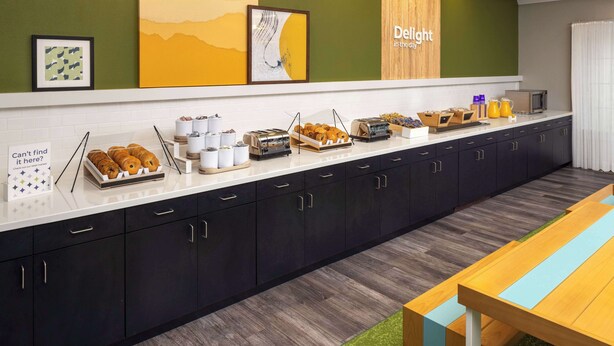 A breakfast bar with pastries, coffee, and juice, and a sign that says "Can't find it here? Check out our store." - Spark by Hilton Houston West Clay Road (Houston)