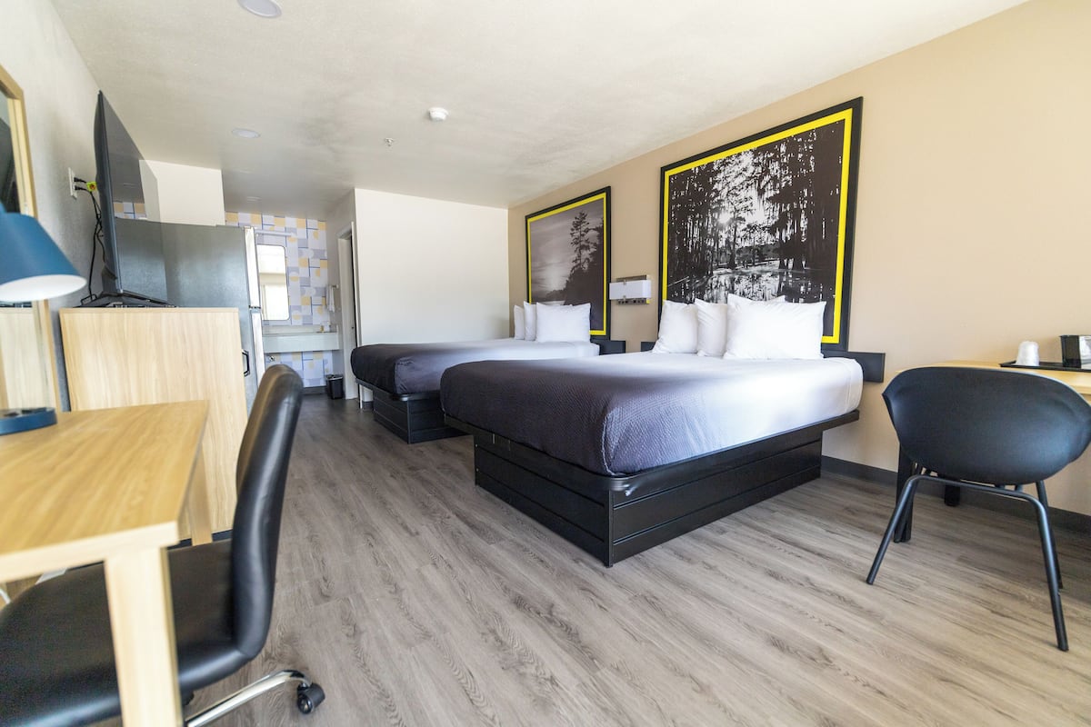 Une chambre d’hôtel avec un lit, un bureau, une chaise et un téléviseur.