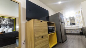 Eine moderne Küche mit Mikrowelle, Kühlschrank und Holzschränken.