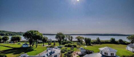 Propiedad residencial con piscina, vista a un lago y césped bien cuidado.