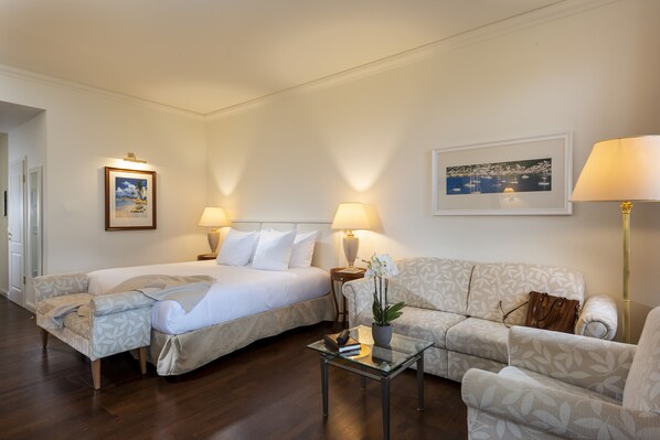 A hotel room with two beds, a sofa, a glass coffee table, and a lamp. - Sunday Resort Schwielowsee (Werder (Havel))