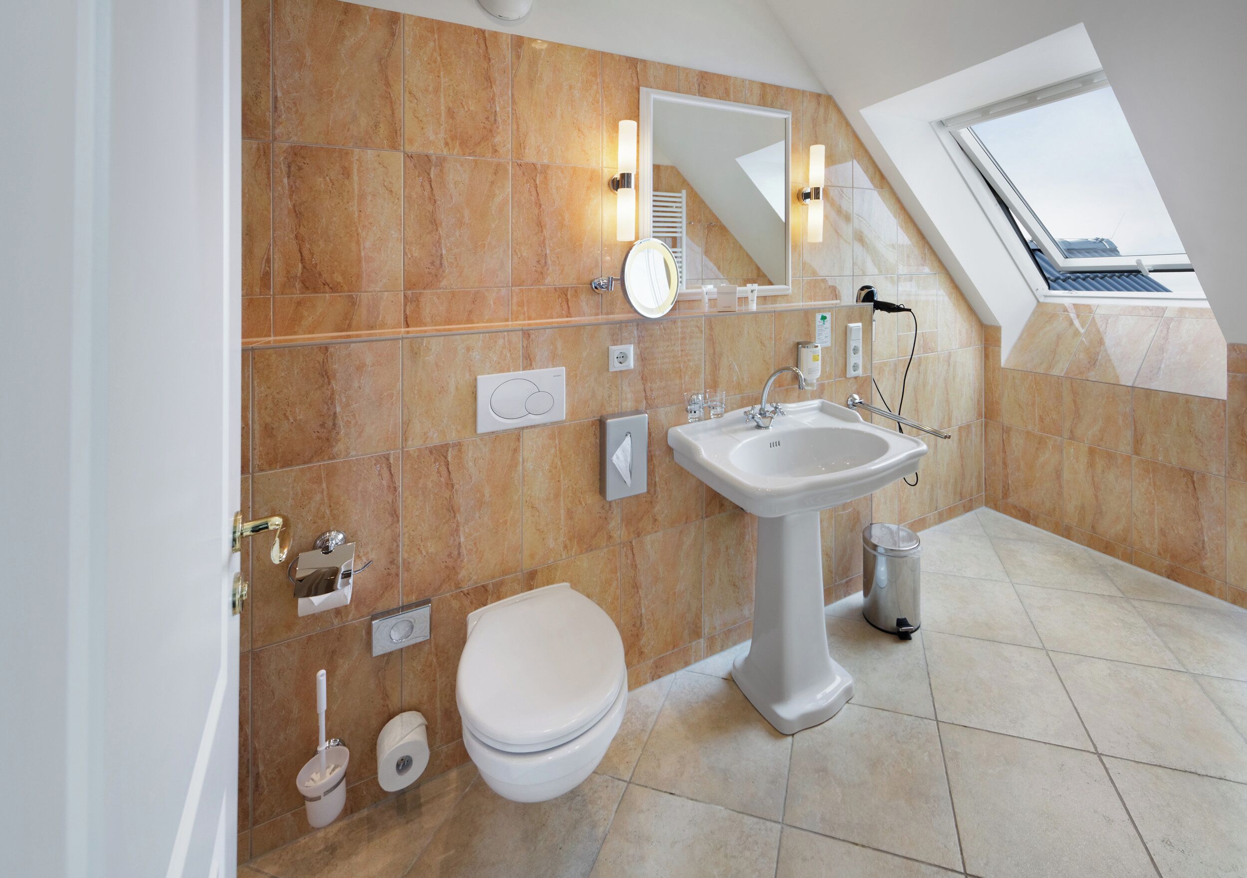 Un baño moderno con lavamanos pedestal, inodoro y bidé.