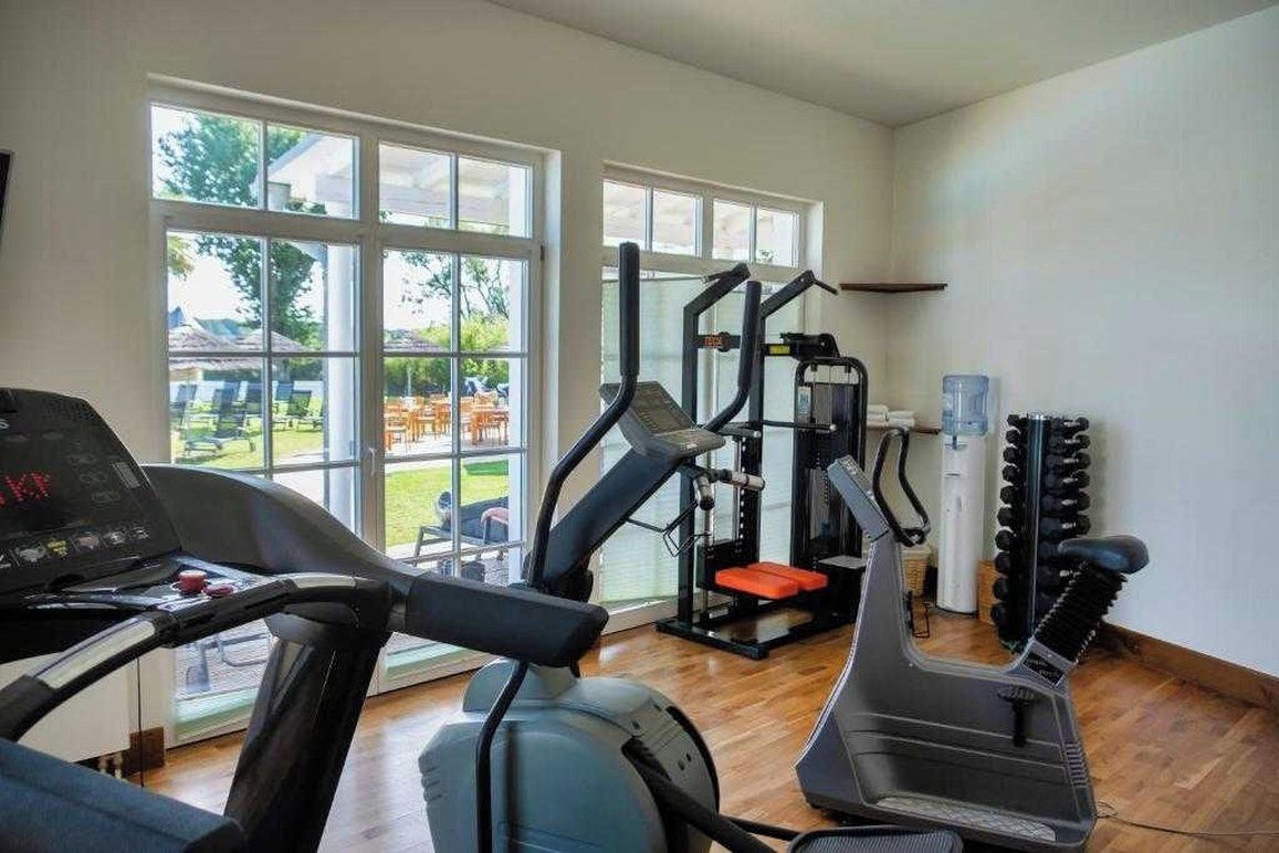 Un gimnasio con cintas de correr, máquinas de pesas y un dispensador de agua.