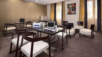 A conference room with a table, chairs, laptops, and a printer.
