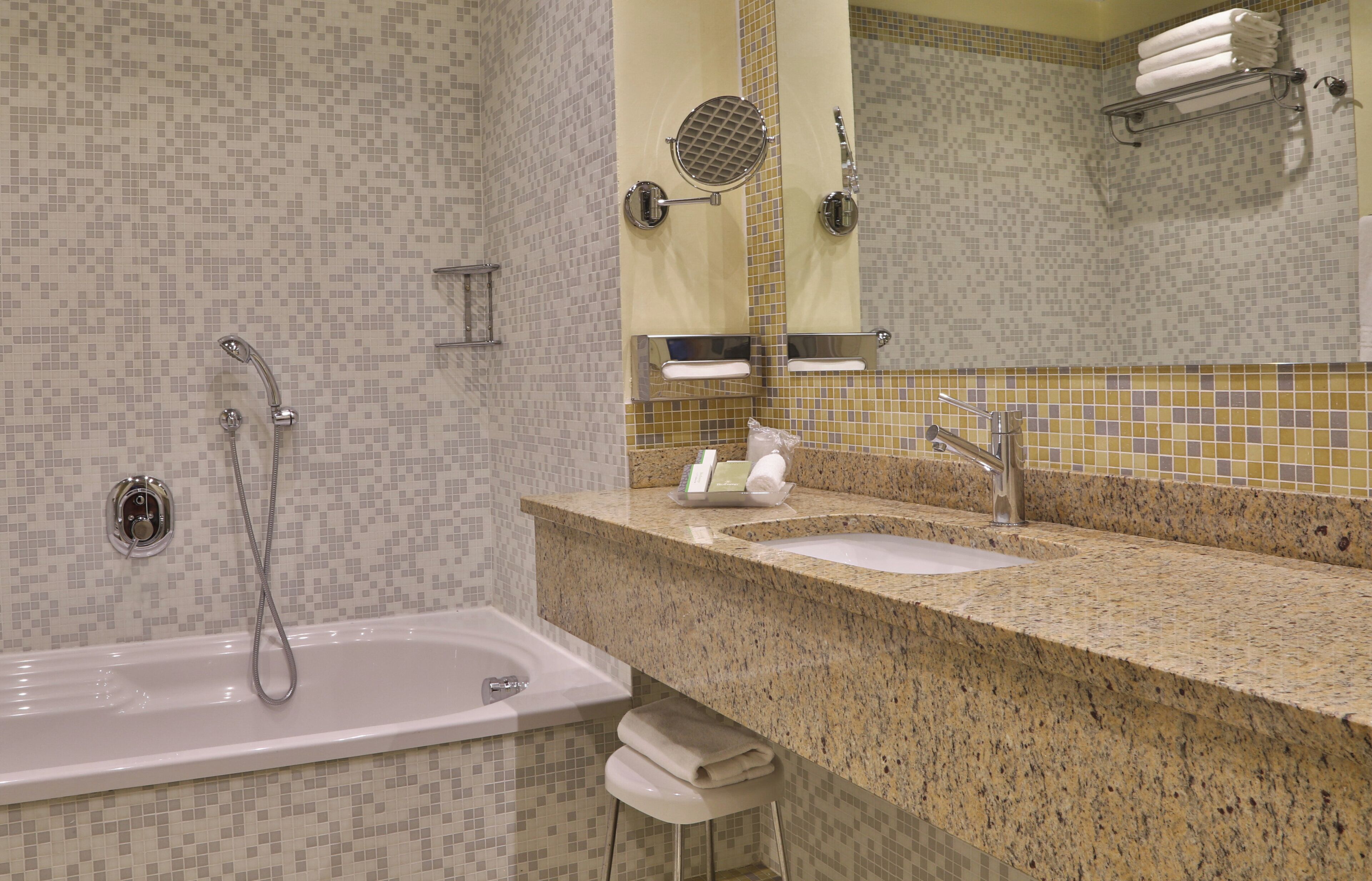 A modern bathroom with a bathtub, a sink, and a mirror.