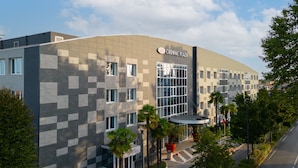 Un edificio moderno con fachada a cuadros, una entrada destacada y un cartel que dice "Crowne Plaza".