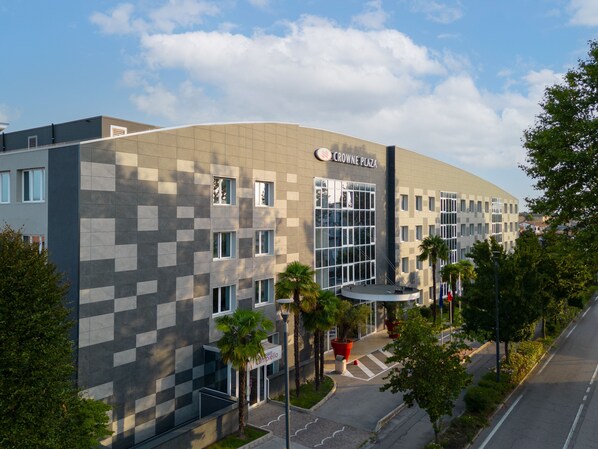 A modern building with a checkered facade, a prominent entrance, and a sign reading "Crowne Plaza."