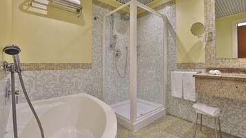 Un bagno con doccia vetrata, una vasca da bagno freestanding, un lavabo con specchio e un porta asciugamani.