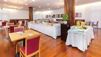 Ein Essbereich mit Tischen, Stühlen und einem Buffet.