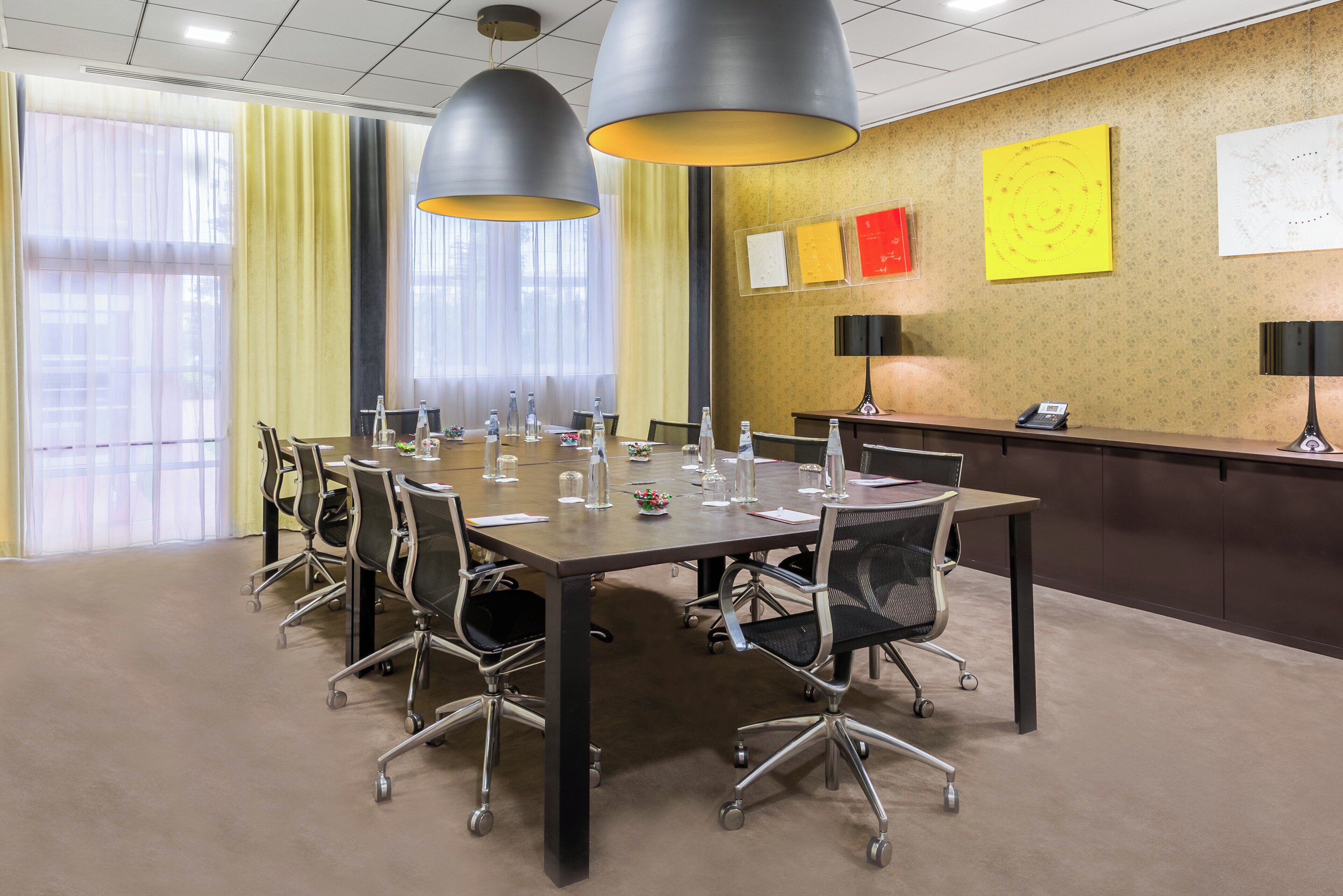 A conference room with a long table, chairs, and a reception desk.