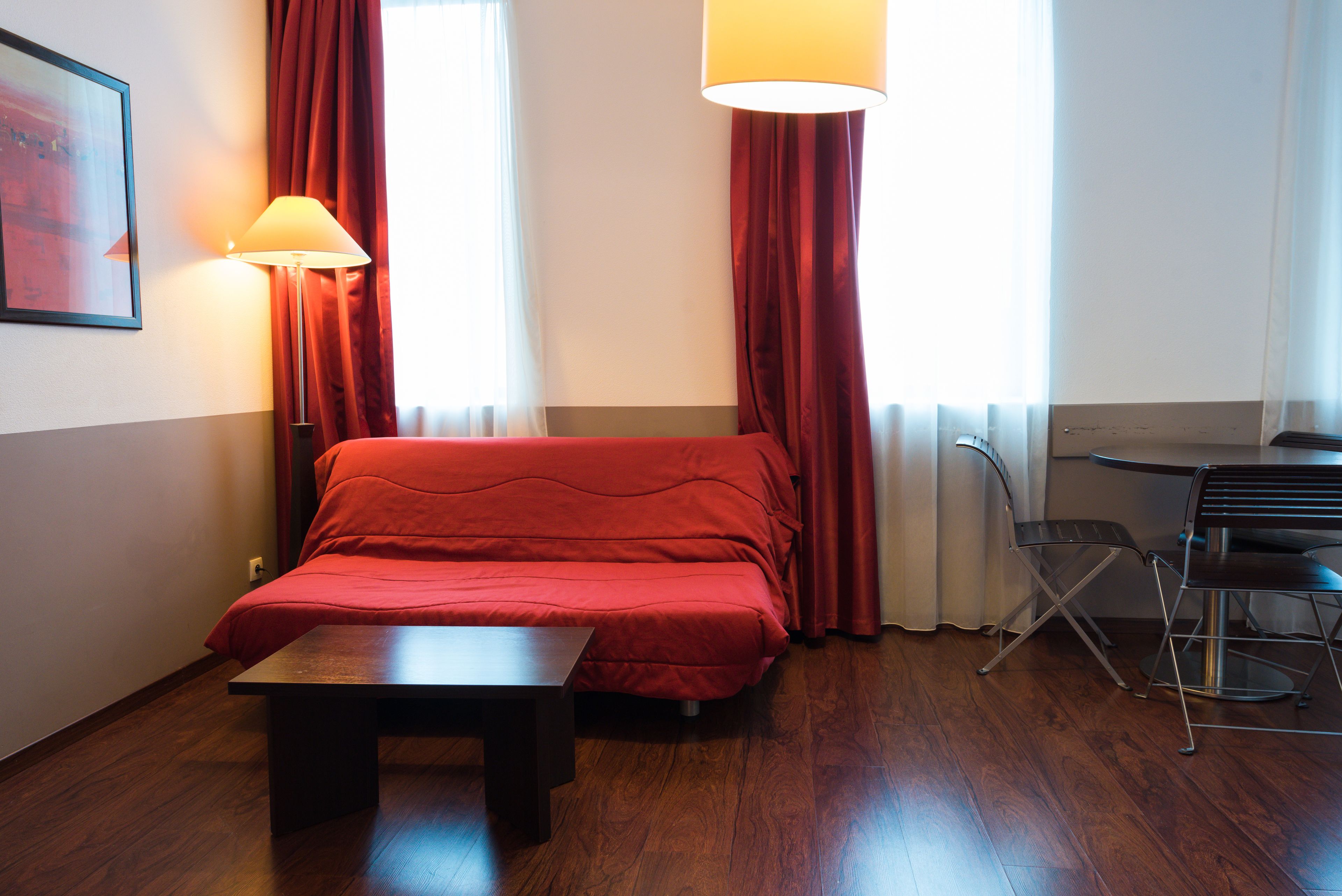A hotel room with a bed, a table, and a chair.