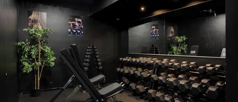 A gym with exercise equipment, including dumbbells and a bench press.