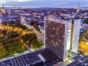 Un hôtel de grande hauteur, doté d’une façade moderne en verre, de nombreux étages et d’une enseigne bien visible au sommet.