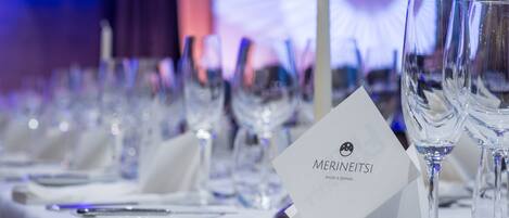 A table set for a formal dining event with a menu card labeled "MERNEITSI SHOW & DINNER".