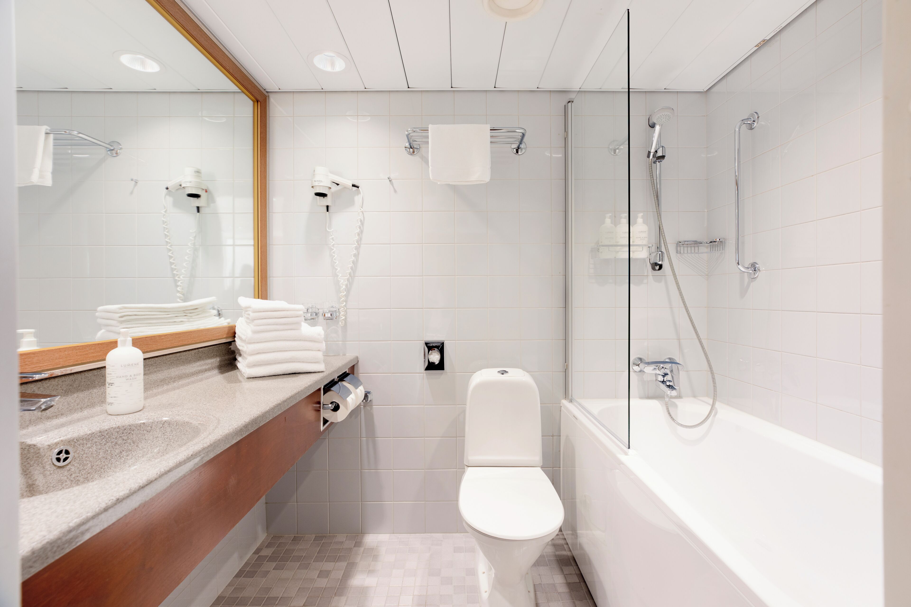 Ein modernes Badezimmer mit Waschtisch, Toilette und einer Duschkabine.