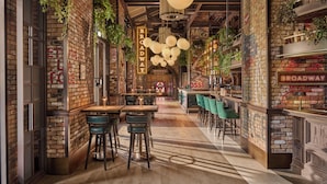A restaurant interior with brick walls, hanging plants, and a bar area with stools. - Emirates Palace Mandarin Oriental, Abu Dhabi (Abu Dhabi)