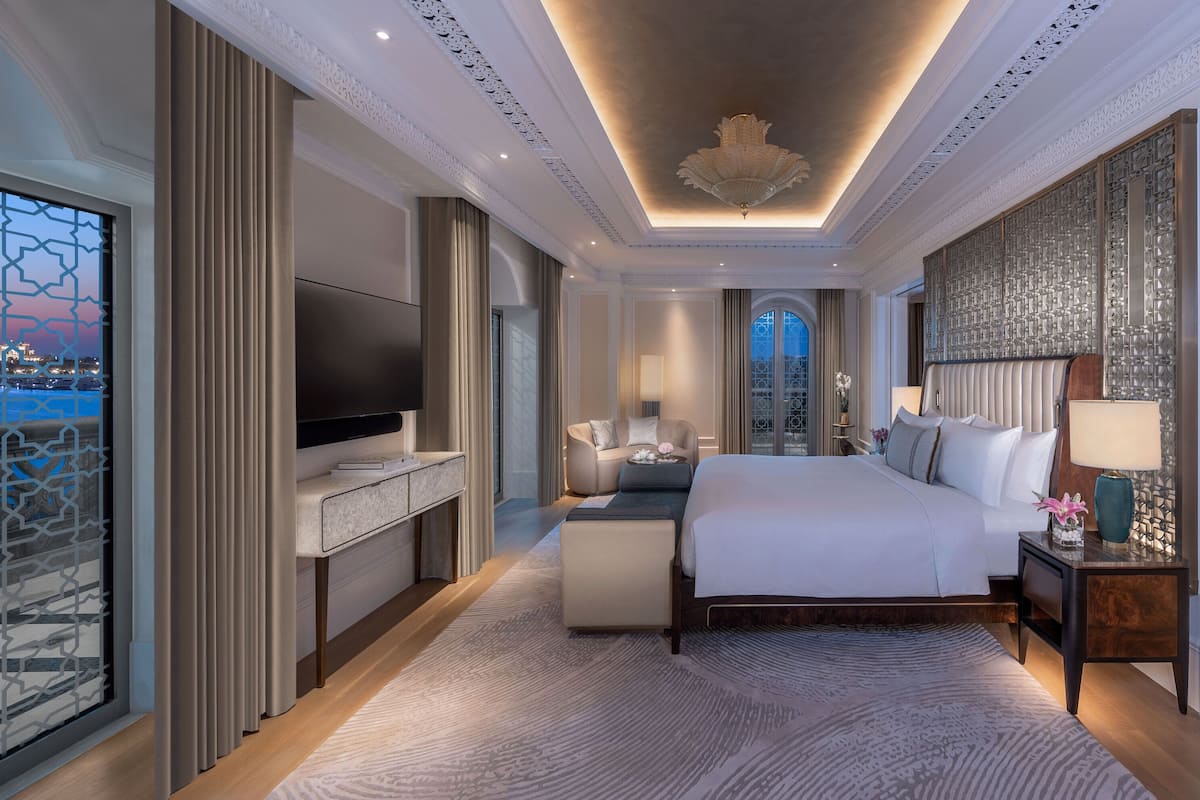 Ein geräumiges Hotelzimmer mit einem großen Bett, einem Flachbildfernseher, einem Schreibtisch und Blick auf die Stadt.