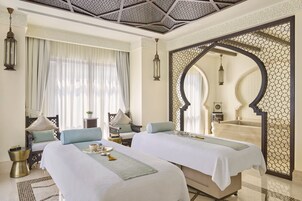 Habitación de hotel con dos camas, un espejo grande y vistas a una piscina.