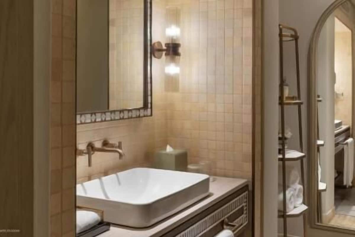 Un baño moderno con una bañera grande, un espejo y un perchero para toallas.