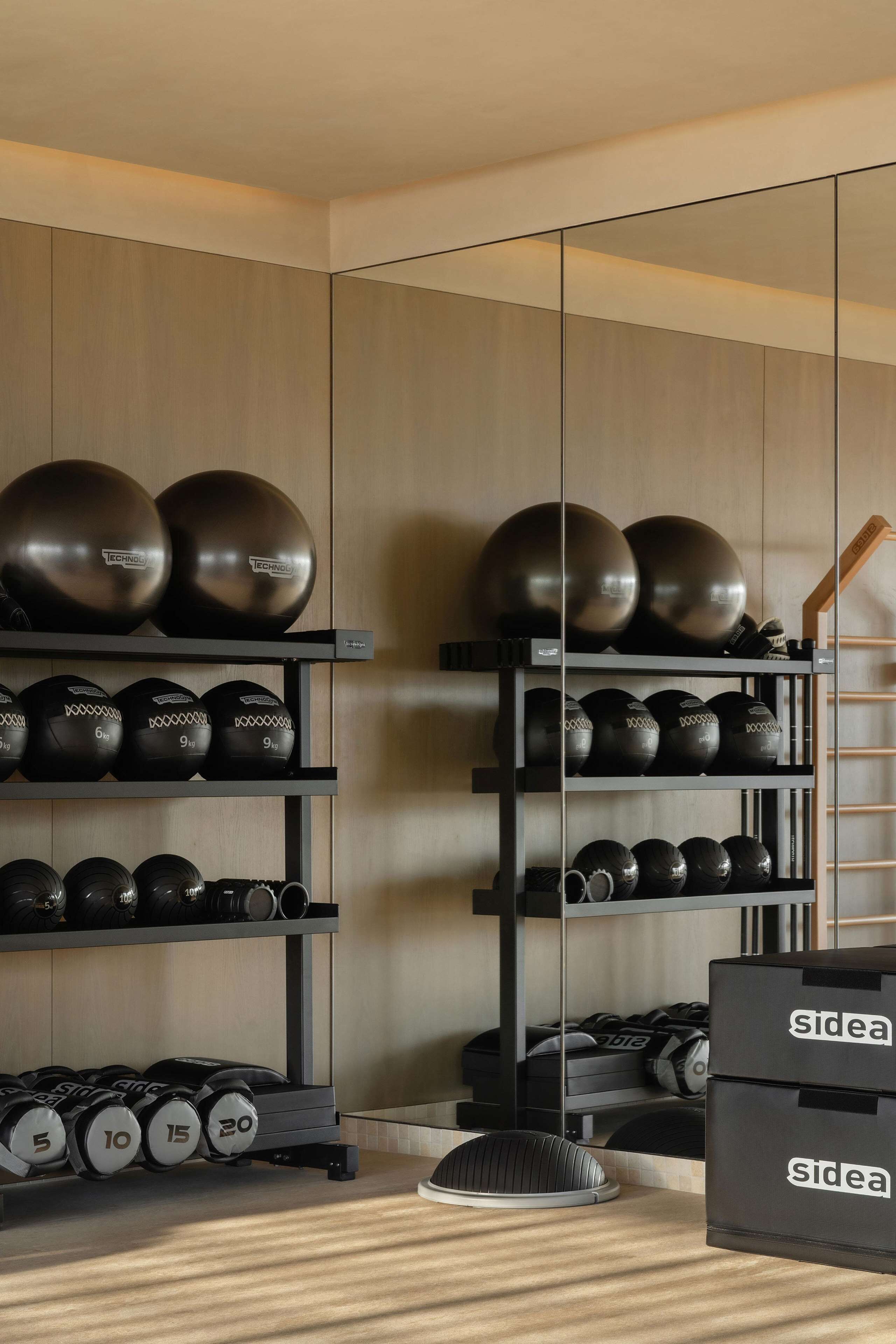 A gym with exercise equipment, including dumbbells, kettlebells, and medicine balls.