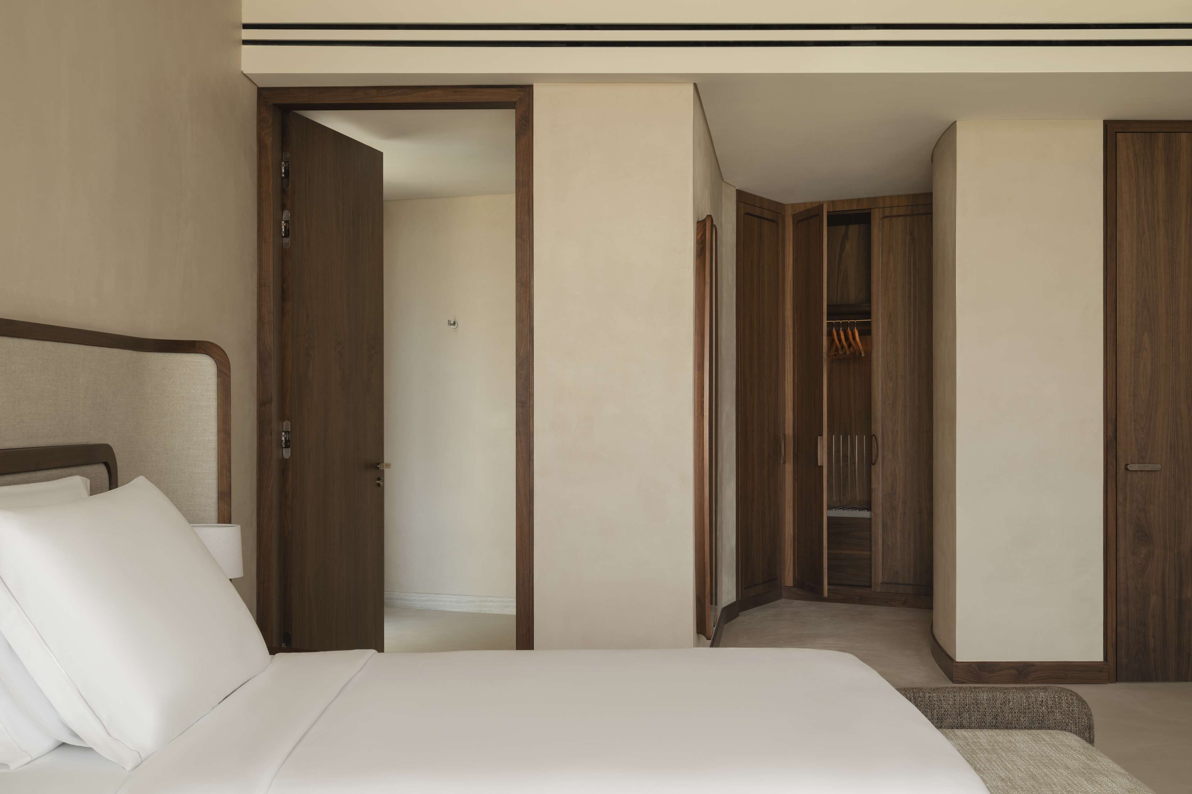 A hotel room with a bed, a wardrobe, and a closet.