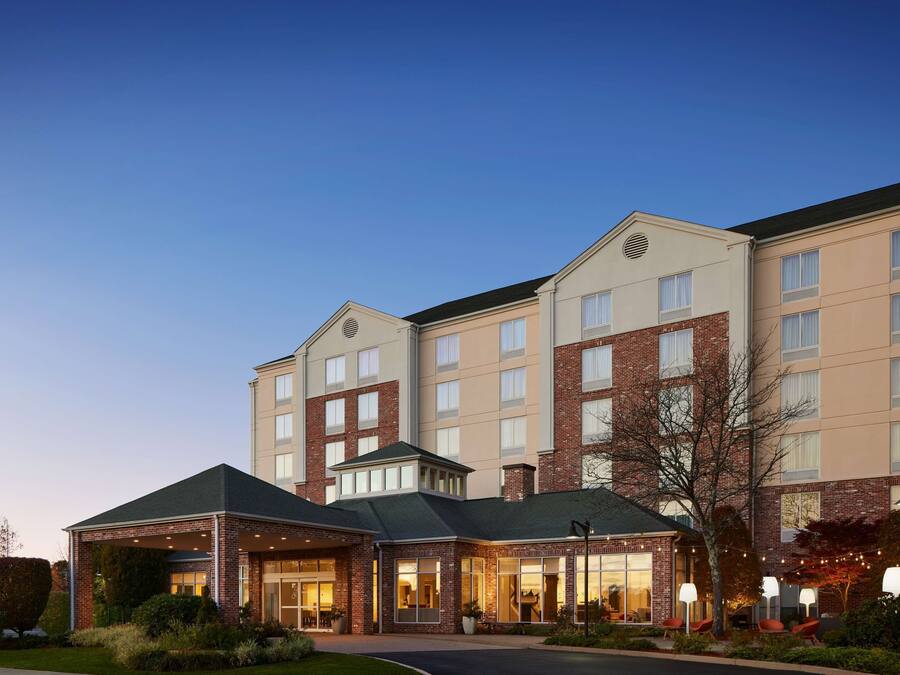 A multi-story hotel with a brick facade, multiple windows, and a covered entrance area.
