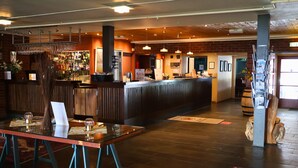 A bar area with a counter, stools, and a table with glasses and menus. - Rauland Høgfjellshotell (Vinje)