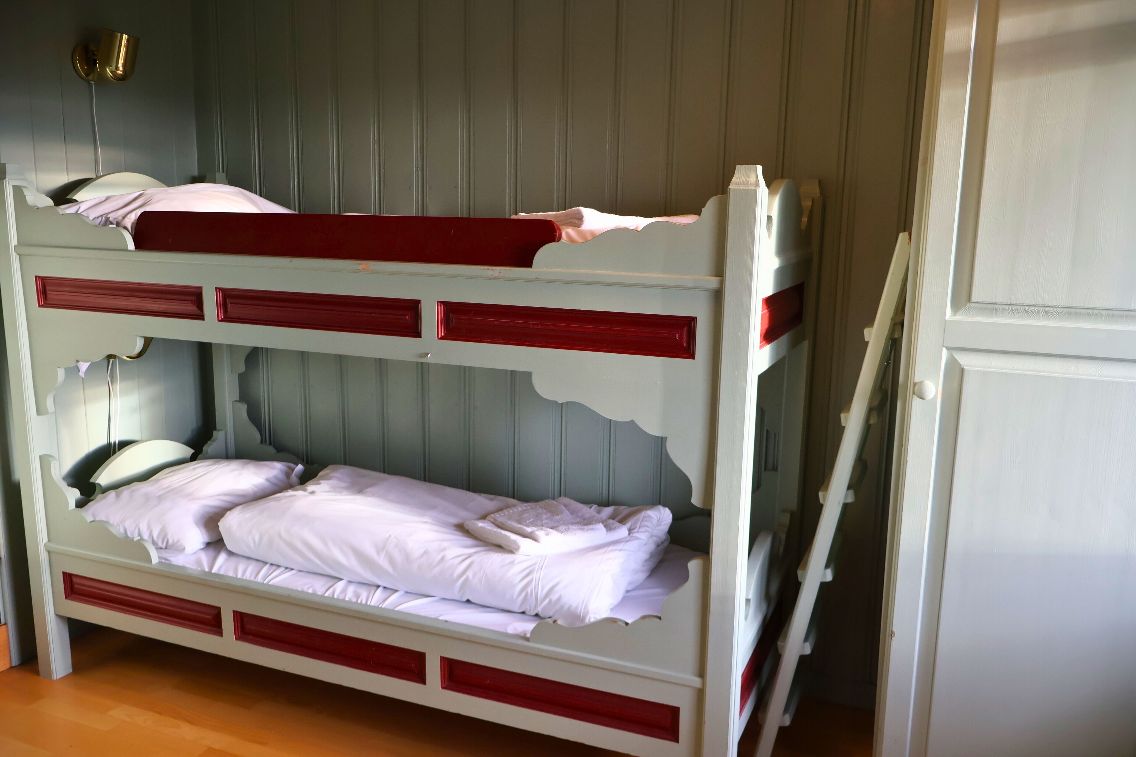Una cama litera con dos niveles, cada uno con almohada y manta.