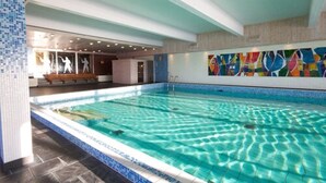An indoor swimming pool with clear water, tiled walls, and a bench near the entrance. - Rauland Høgfjellshotell (Vinje)