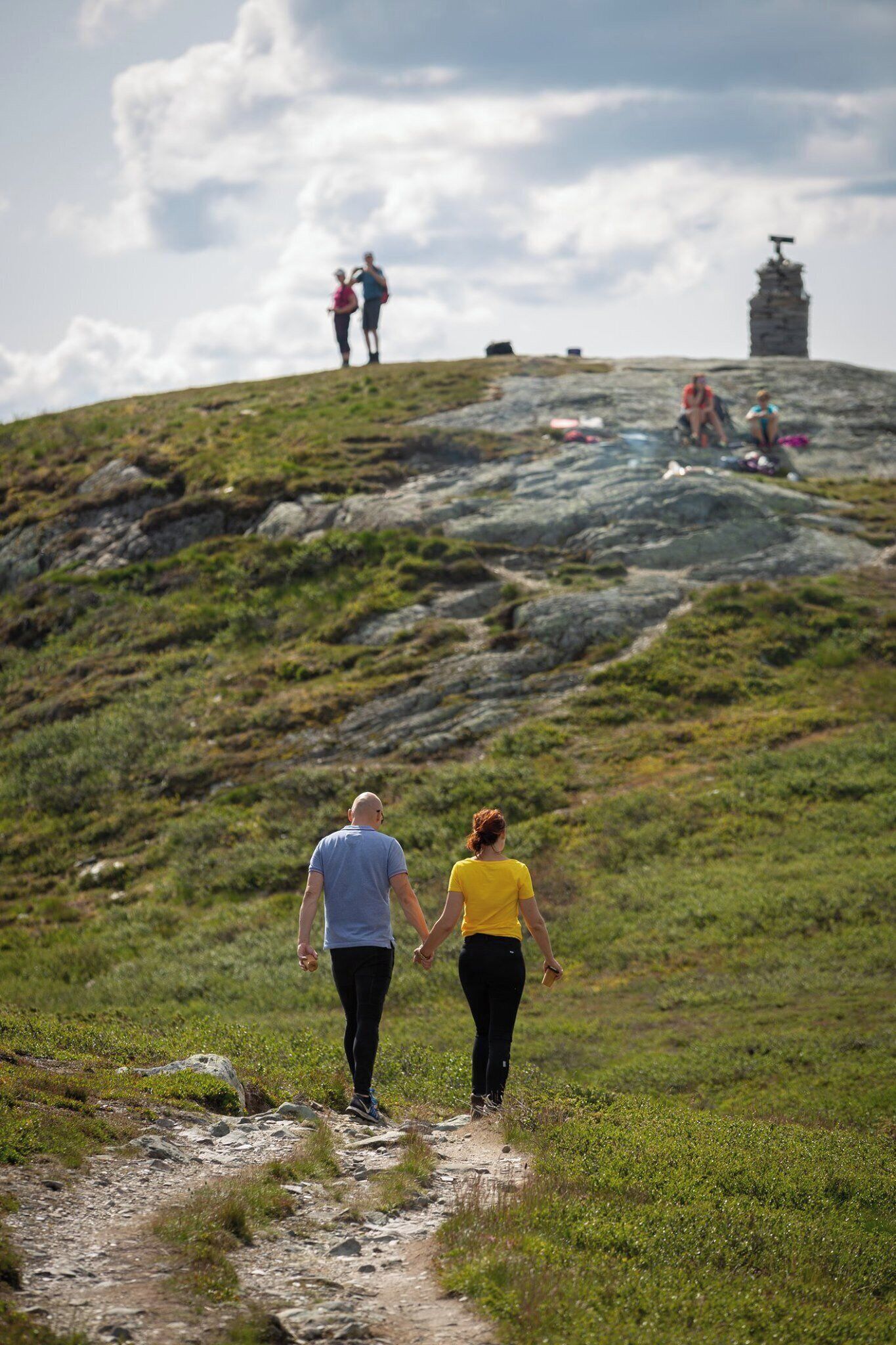 A hilly landscape with a path leading up to a monument.