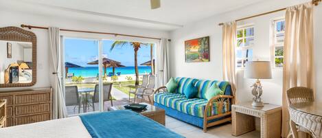 Una habitación de hotel con una cama, un sofá, un escritorio y vistas a la playa.