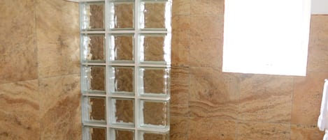 A bathroom with a toilet, bidet, and a glass shower enclosure.
