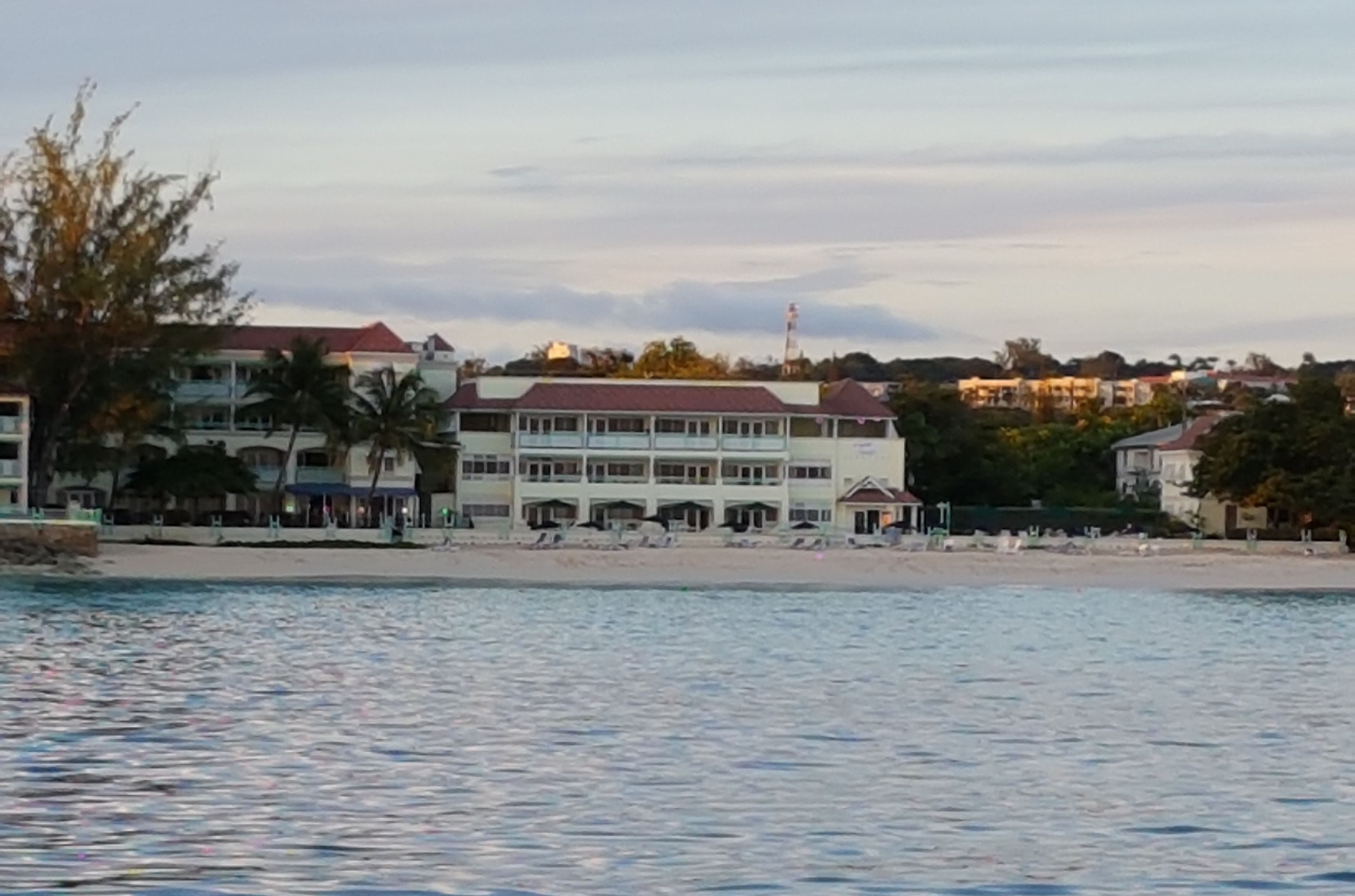 Hotel à beira-mar com vários andares, piscina e comodidades na praia.