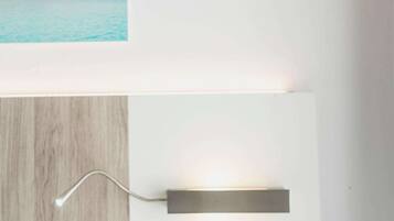 Un dormitorio moderno con cabecera de madera, una mesita de noche y una lámpara de pared.