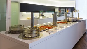 Montaje de bufé con diversos alimentos y cristalería.
