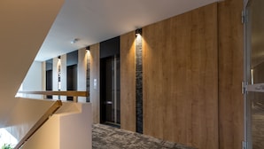 Un interior moderno con pared de madera, suelo alfombrado y una escalera.