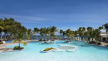 Relax by the serene pool surrounded by palm trees and comfortable seating options.