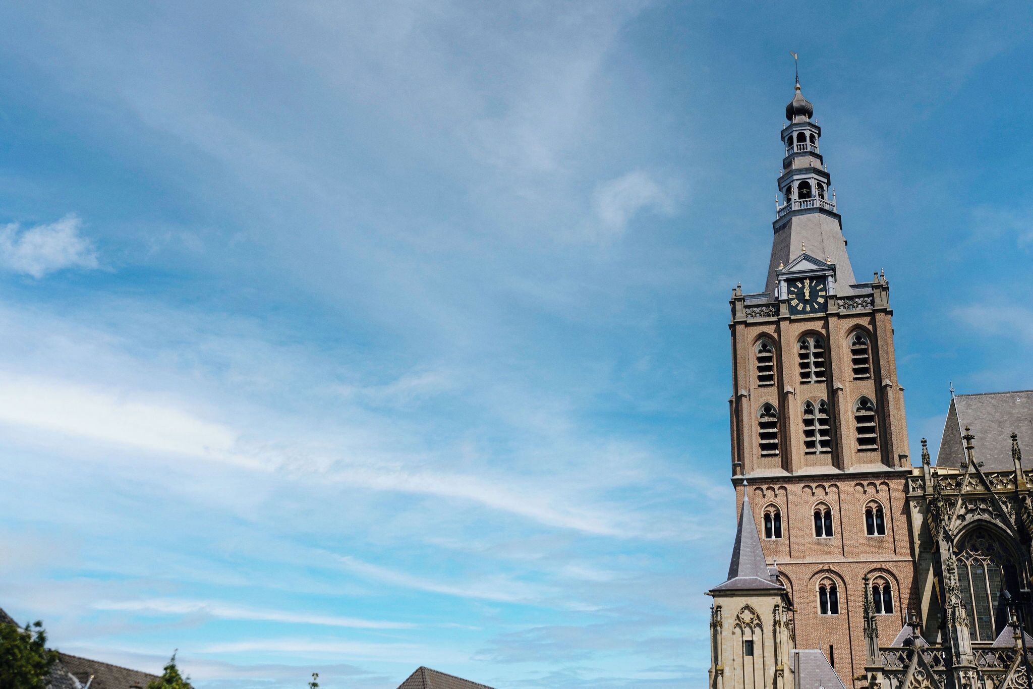 Een hoge kerk met een klokkentoren en een puntige toren.
