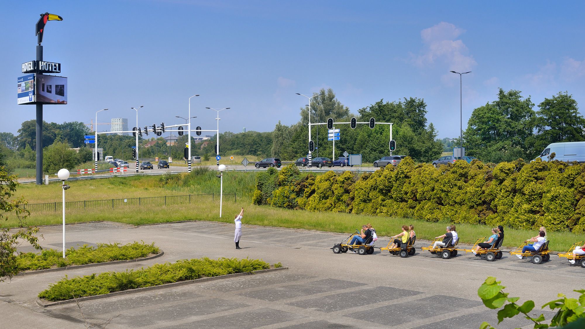 A hotel sign, a traffic light, and a road with vehicles.