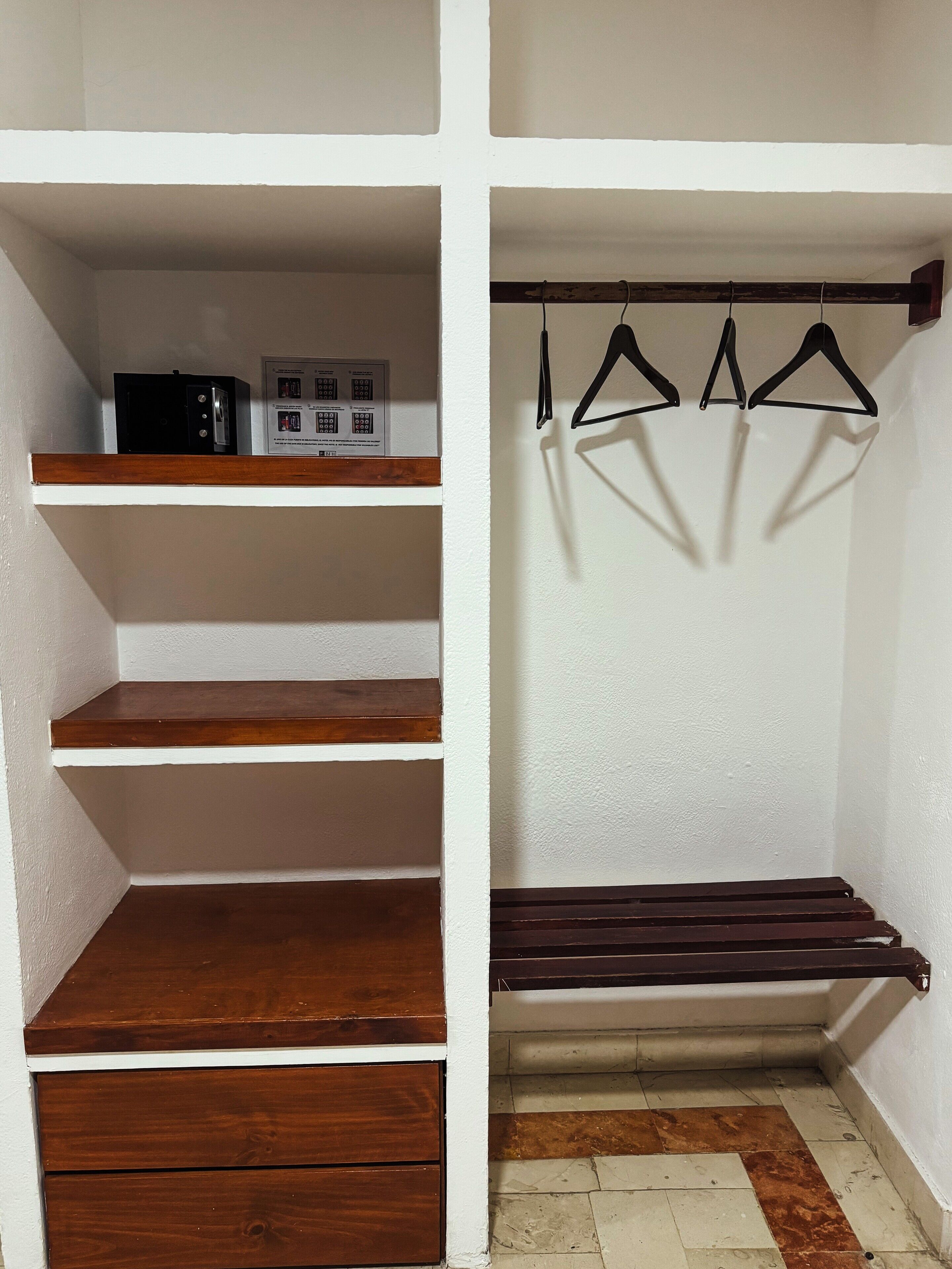 A closet with wooden shelves, a hanging rod, and a built-in bench.