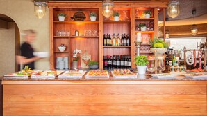 Una zona de bar con estanterías de madera, botellas de vino y diferentes vasos.