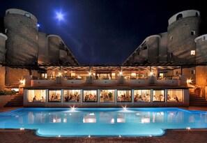 A hotel with a swimming pool, multiple dining areas, and a castle-like structure with towers. - Grand Hotel Smeraldo Beach (Arzachena)