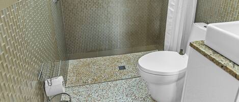A bathroom with a shower, toilet, and a sink.